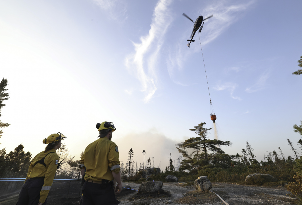 A helicopter drops water on the wildfire.