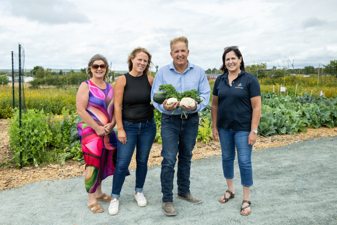 Scott Armstong, Minister of Opportunities and Social Development, and members of the Colchester Food Network next to their community garden.