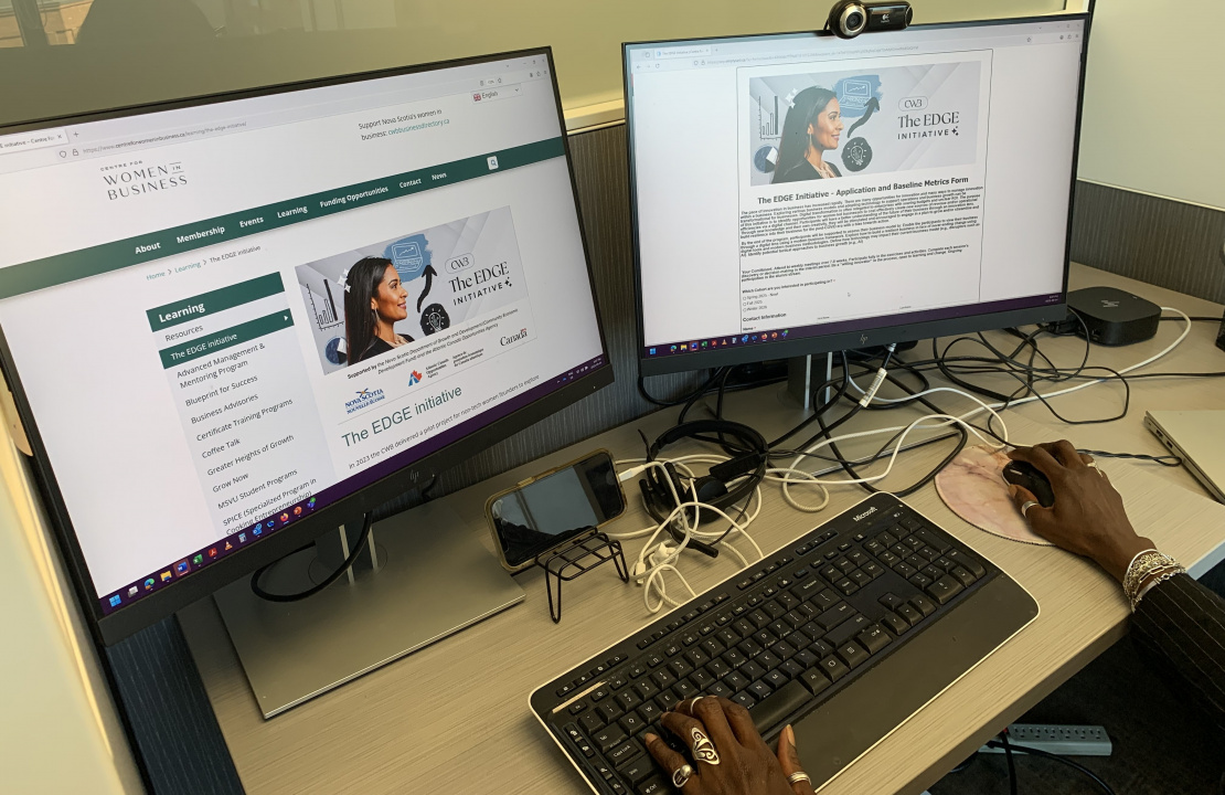 Two computer screens with the Centre for Women in Business website open