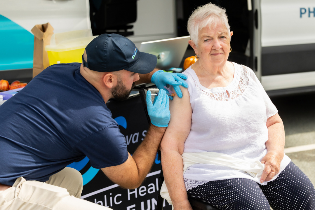 Une aînée reçoit un vaccin dans une unité mobile de santé publique à Halifax.