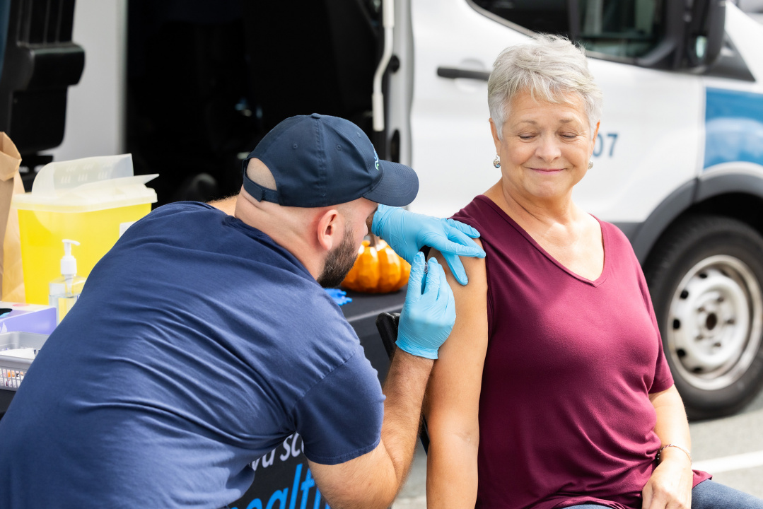 Une aînée reçoit un vaccin dans une unité mobile de santé publique à Halifax.
