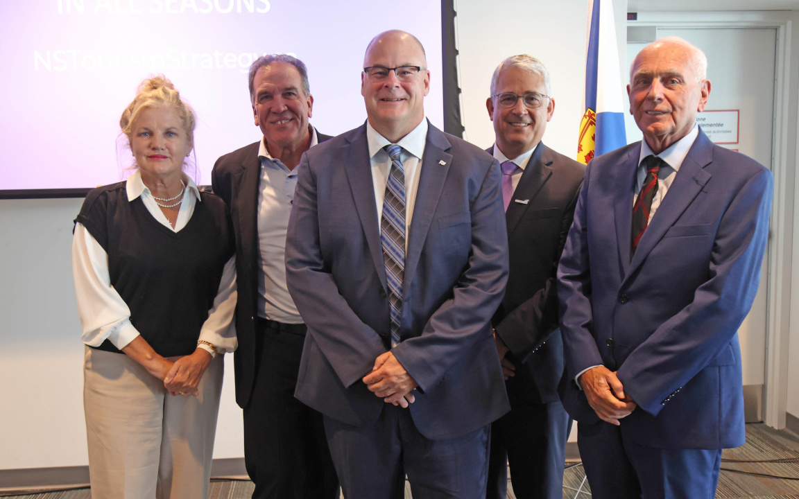 Five people posing for a photo after an announcement