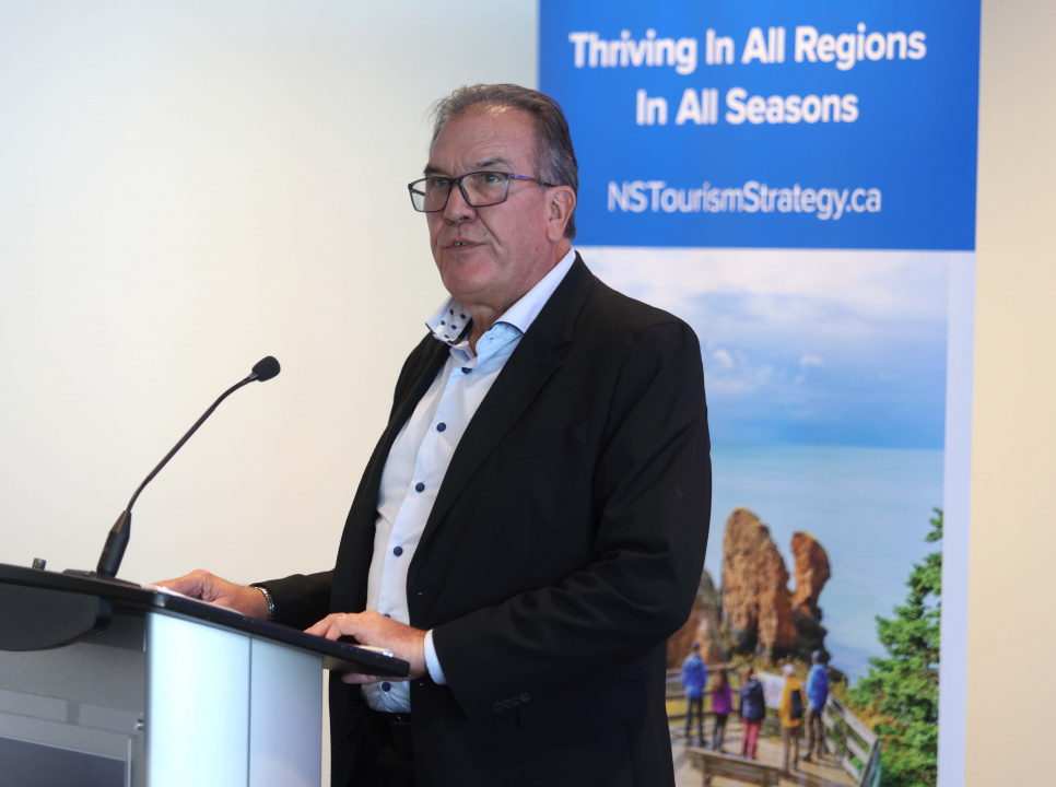 Kevin Toth – Chair of TIANS Board, President of Fox Harb’r Resort, at a podium
