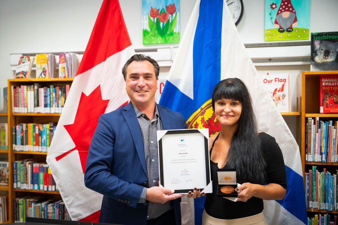 Minister Nolan Young presents the 2025 COF Literacy Award to recipient Mary Smith.