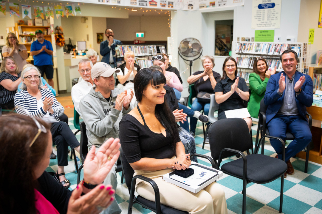 The crowd applauds Mary Smith (centre), 2025 COF Literacy Award winner.
