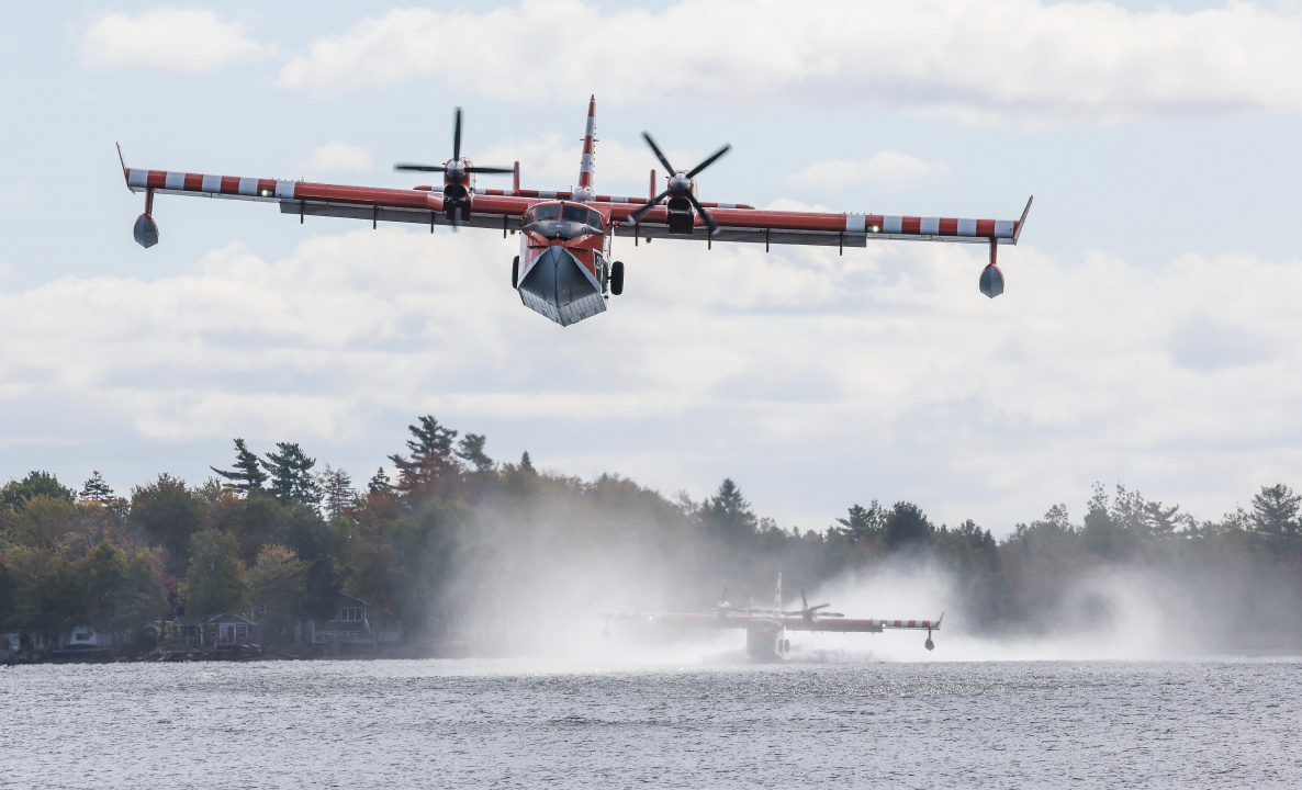 Two planes scooping water from a lake