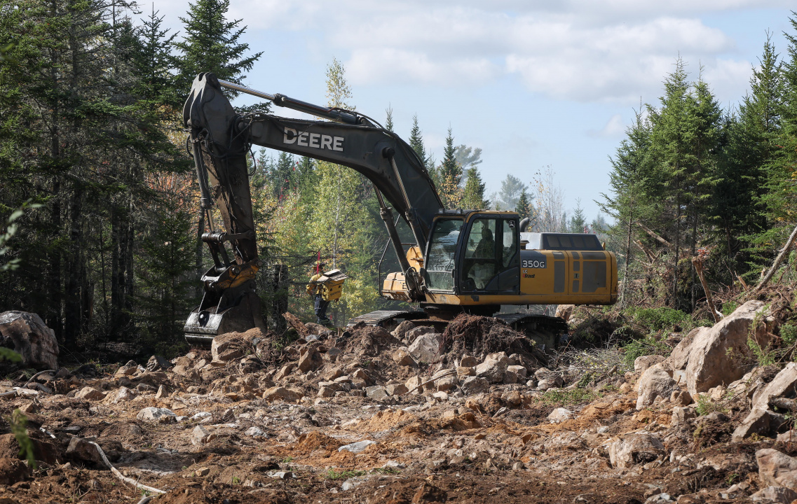 An excavator works on a fire break at the Lake George wildfire