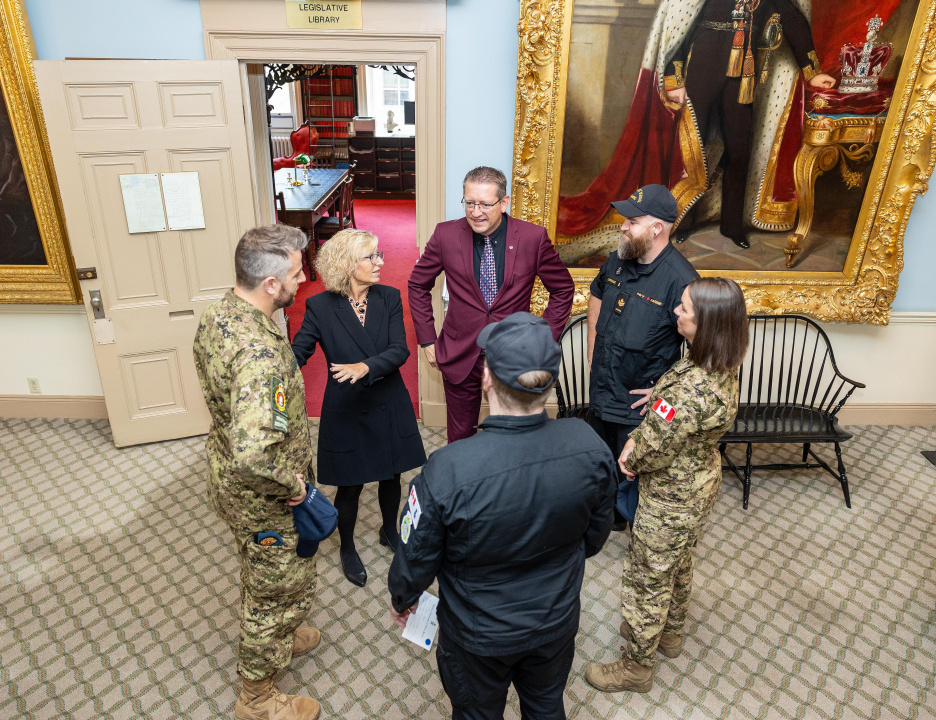 Military Relations Minister Barbara Adams and ministerial assistant Chris Palmer speak with members of the military outside the legislative library at Province House