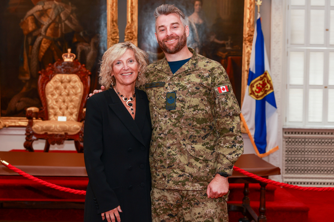 Barbara Adams, Deputy Premier and Minister responsible for Military Relations, stands in Province House's Red Chamber Room with her son Sergeant John Lavoie