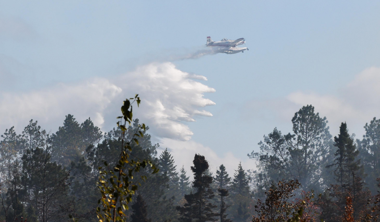 A plane dropping water on a wildfire