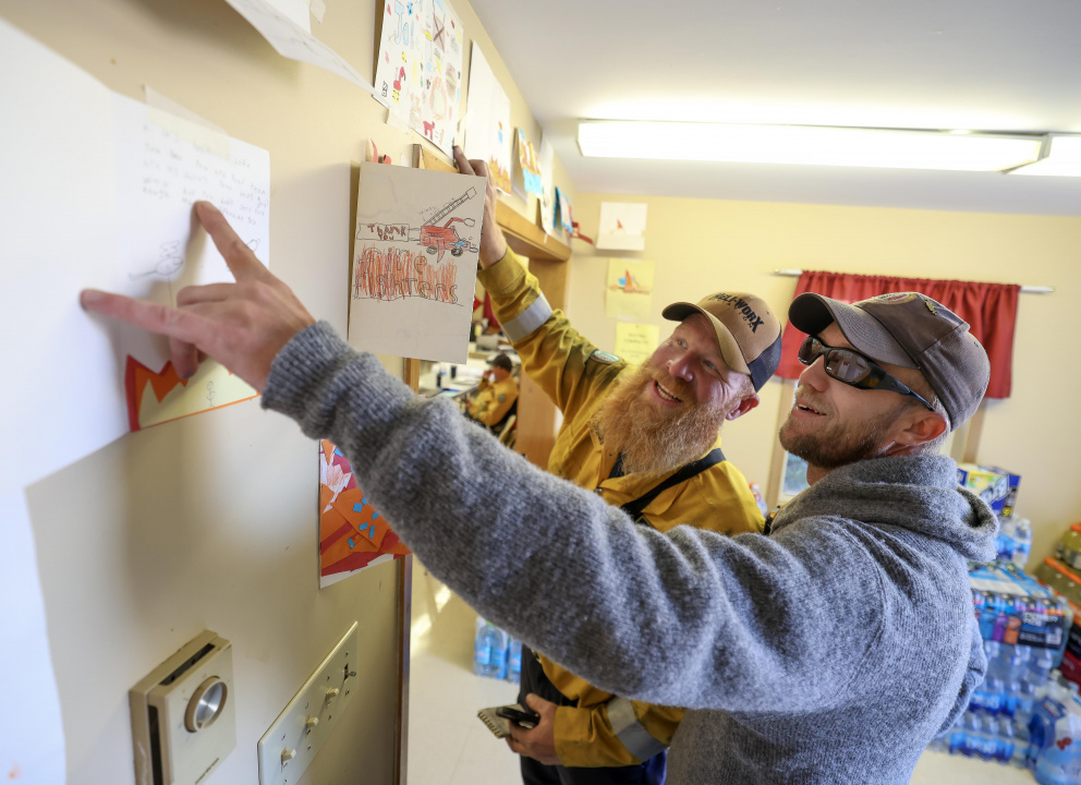 DNR’s Cory Isenor, Operations Section Chief, and Robert Lefurgey, Helicopter Coordinator, smile as they read over the cards sent from Mrs. Johns grade 5 class at Champlain Elementary School to the incident command post at the Morristown Community Centre. 
