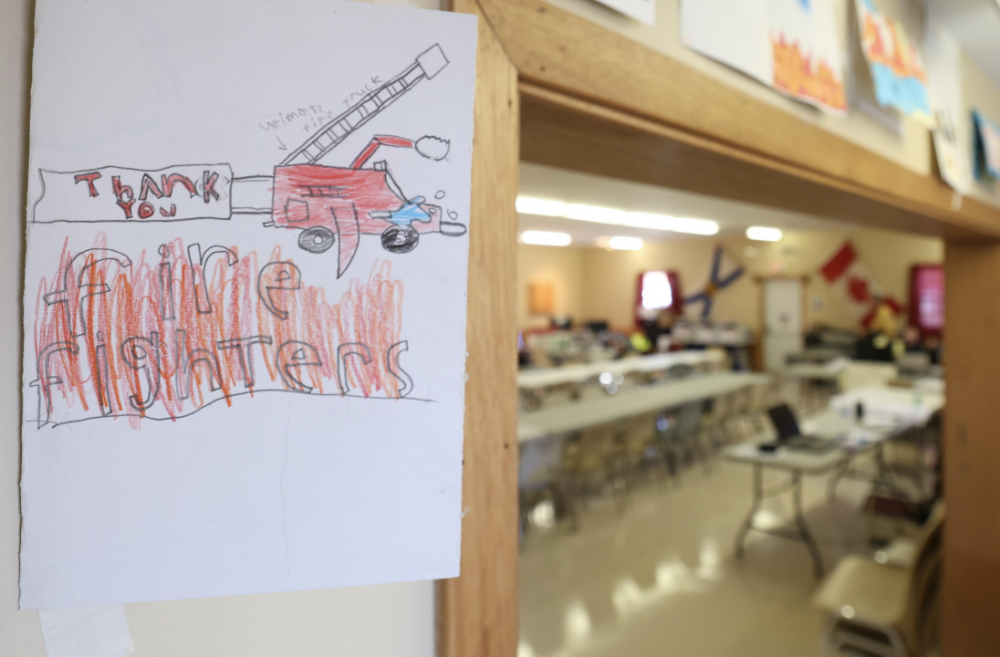 A Grade 5 students’ thank you card to firefighters, with part of the incident command post in the background.