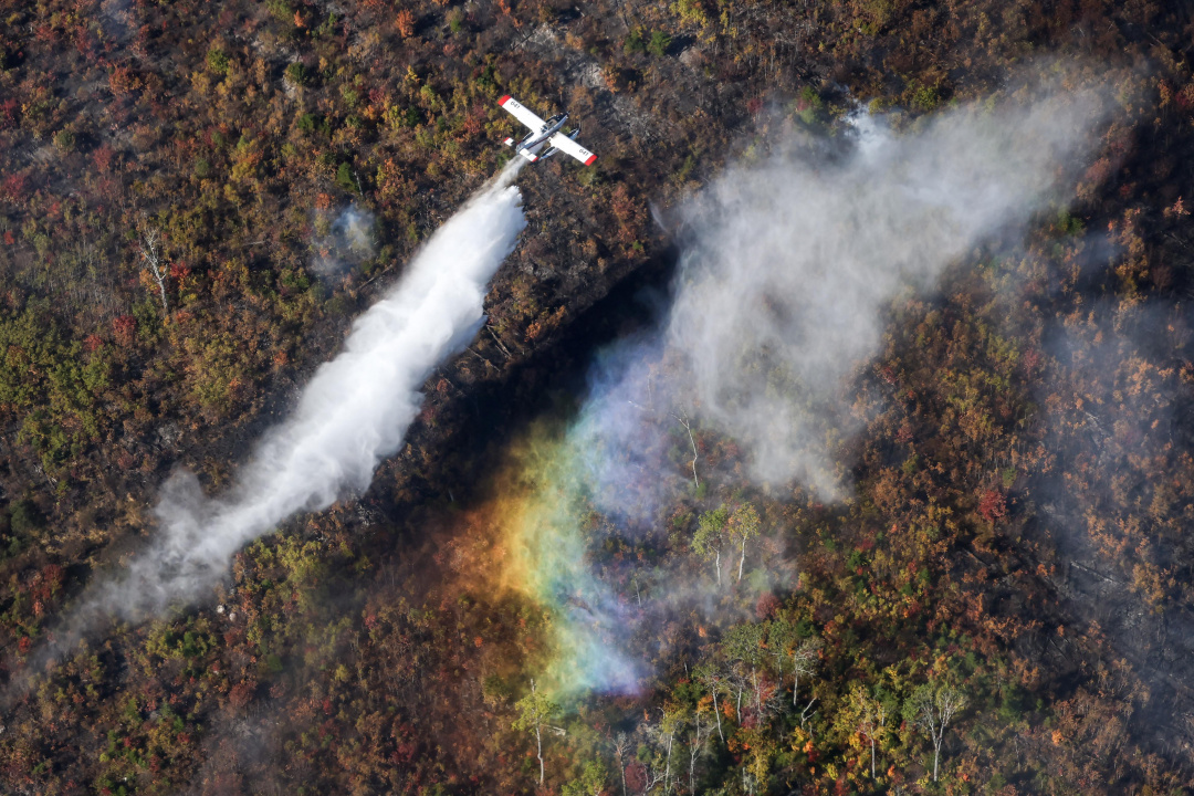 Aerial photo of a plane dropping water on the Lake George wildfire