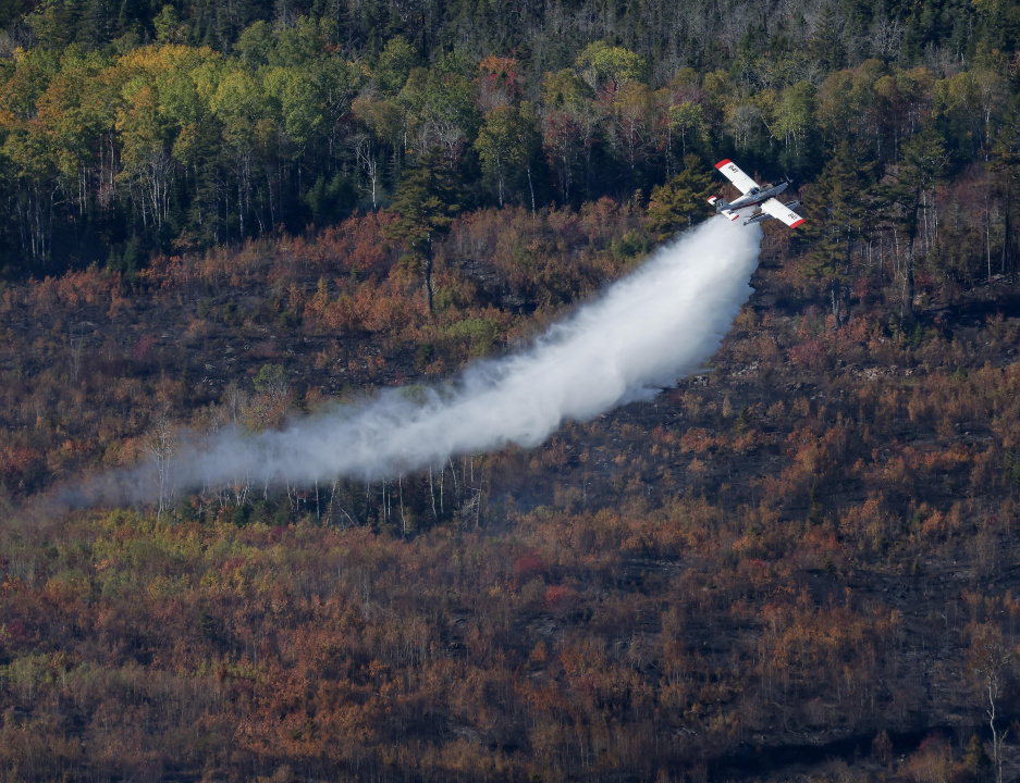 Aerial photo of a plane dropping water on the Lake George wildfire