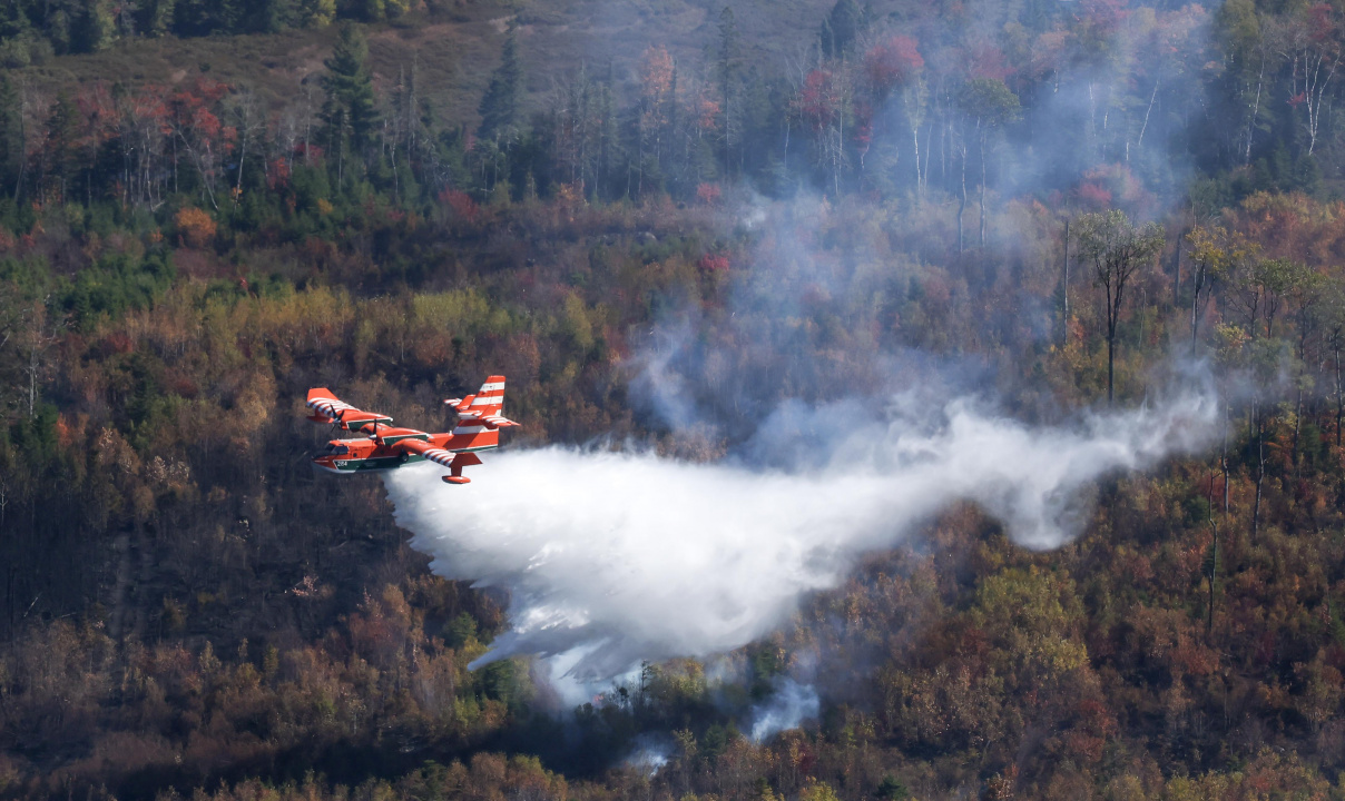 Aerial photo of a plane dropping water on the Lake George wildfire