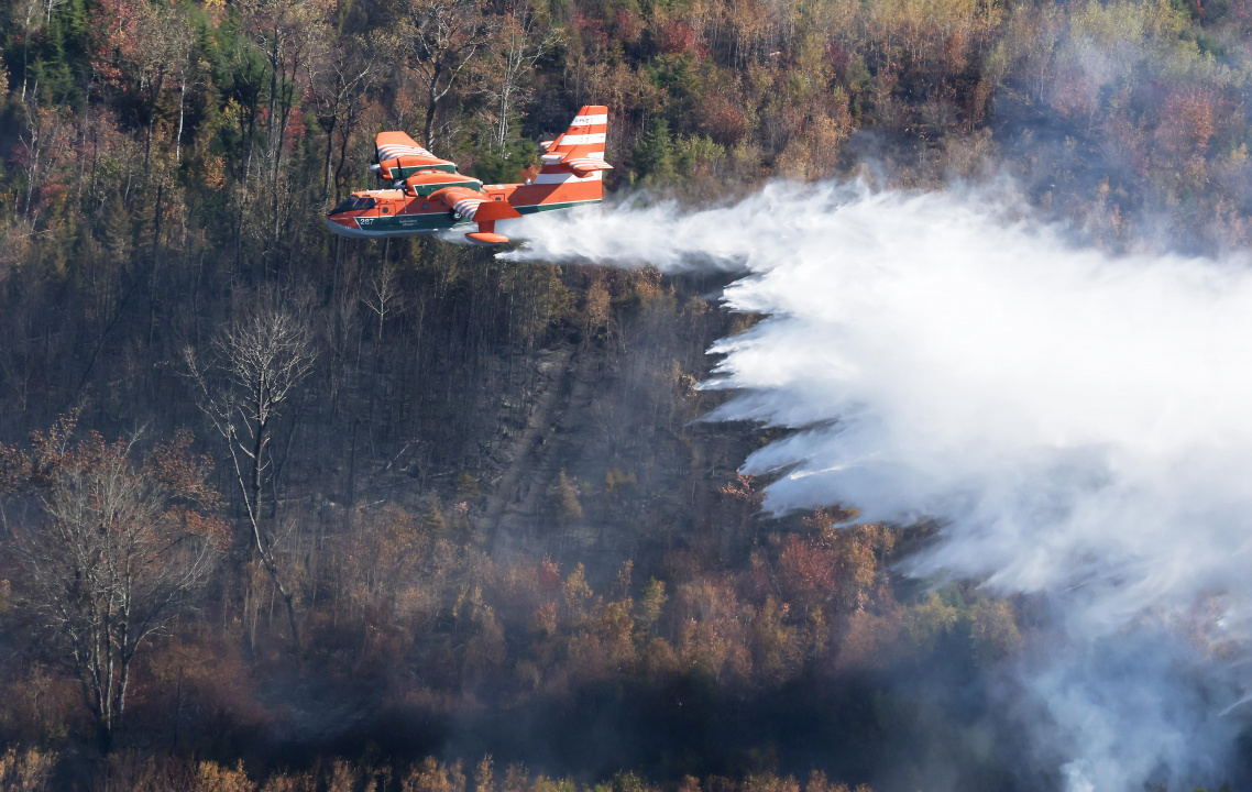 Aerial photo of a plane dropping water on the Lake George wildfire