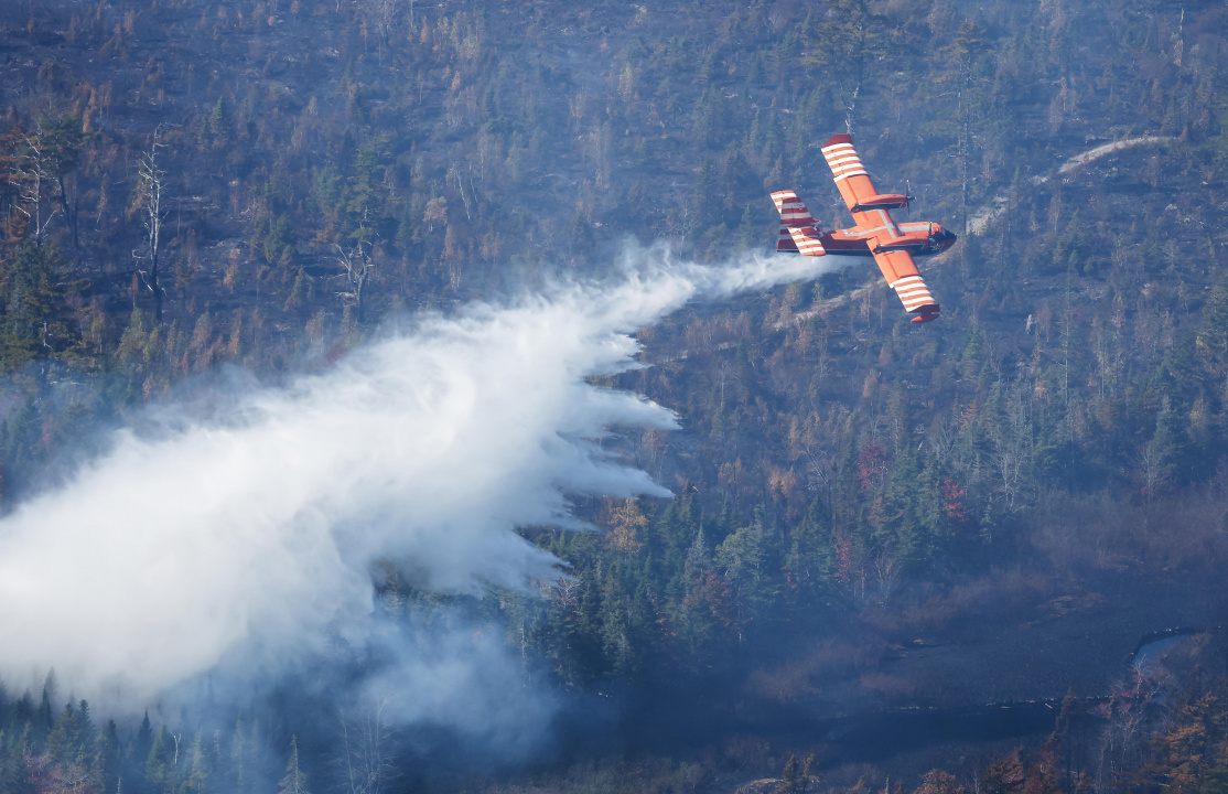 Aerial photo of a plane dropping water on the Lake George wildfire