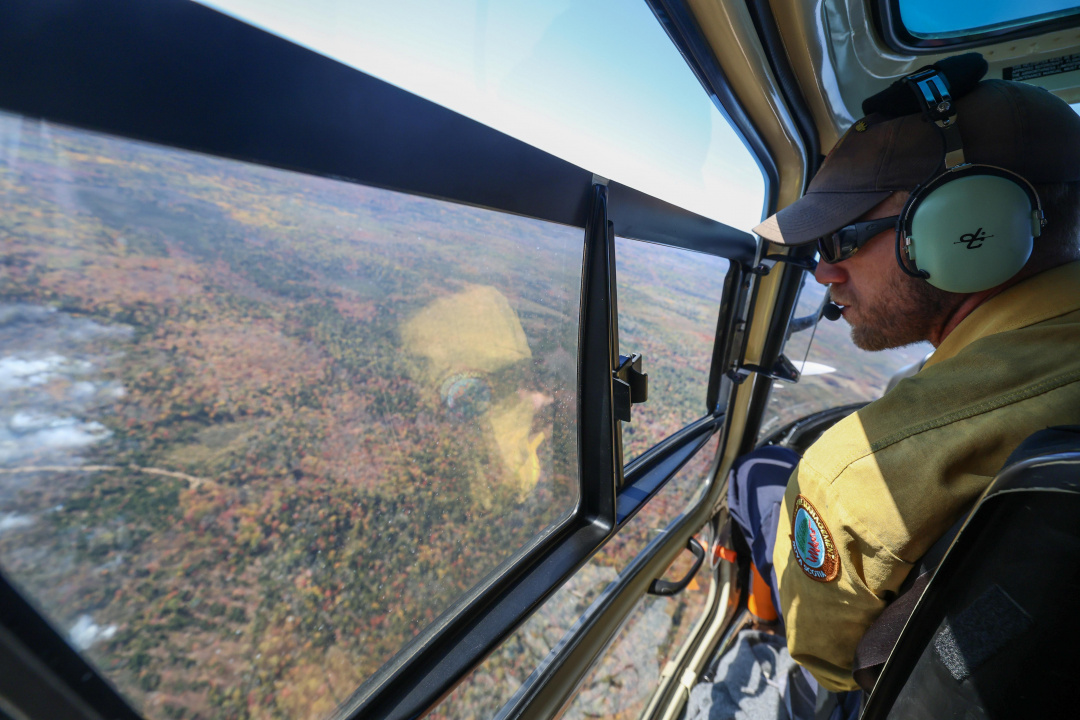 Photo of a pilot in a plane over the Lake George wildfire