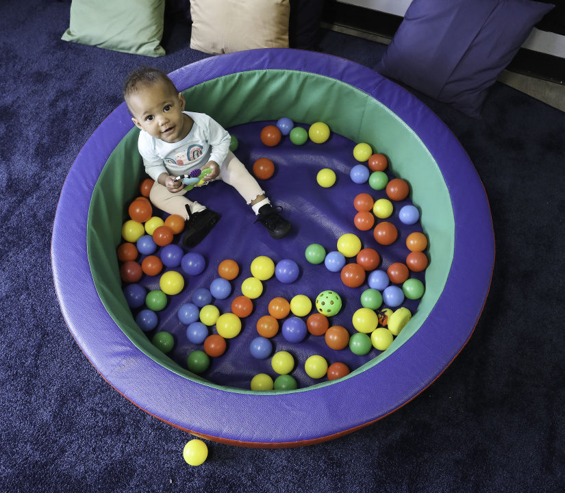 Infant surrounded by balls