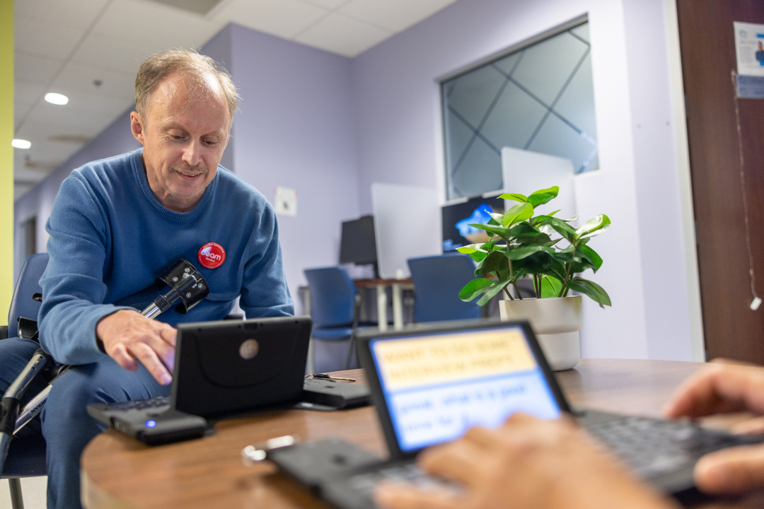 A man with a disability using a portable device keyboard