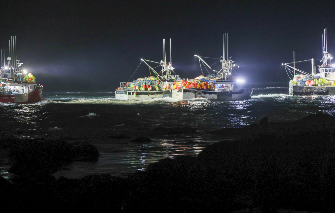 Lobster fishing boats with lights on before daylight