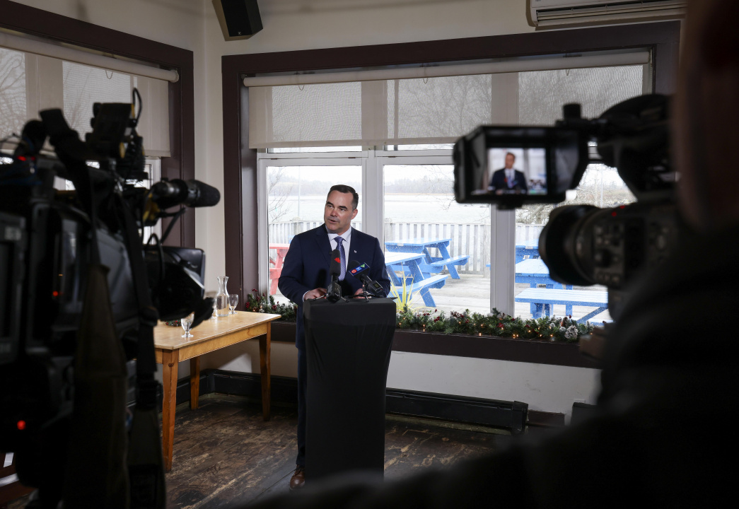 Fisheries and Aquaculture Minister Kent Smith at a podium in front of TV cameras