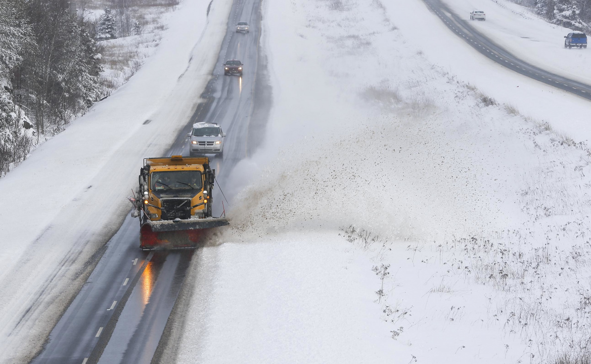 Vehicles following a snowplow on a highway in winter
