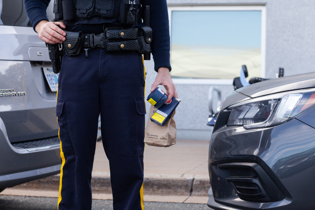 A law enforcement officer holding legal packets of cannabis