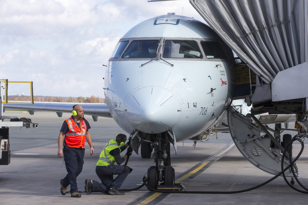 Workers fuel up a plane.