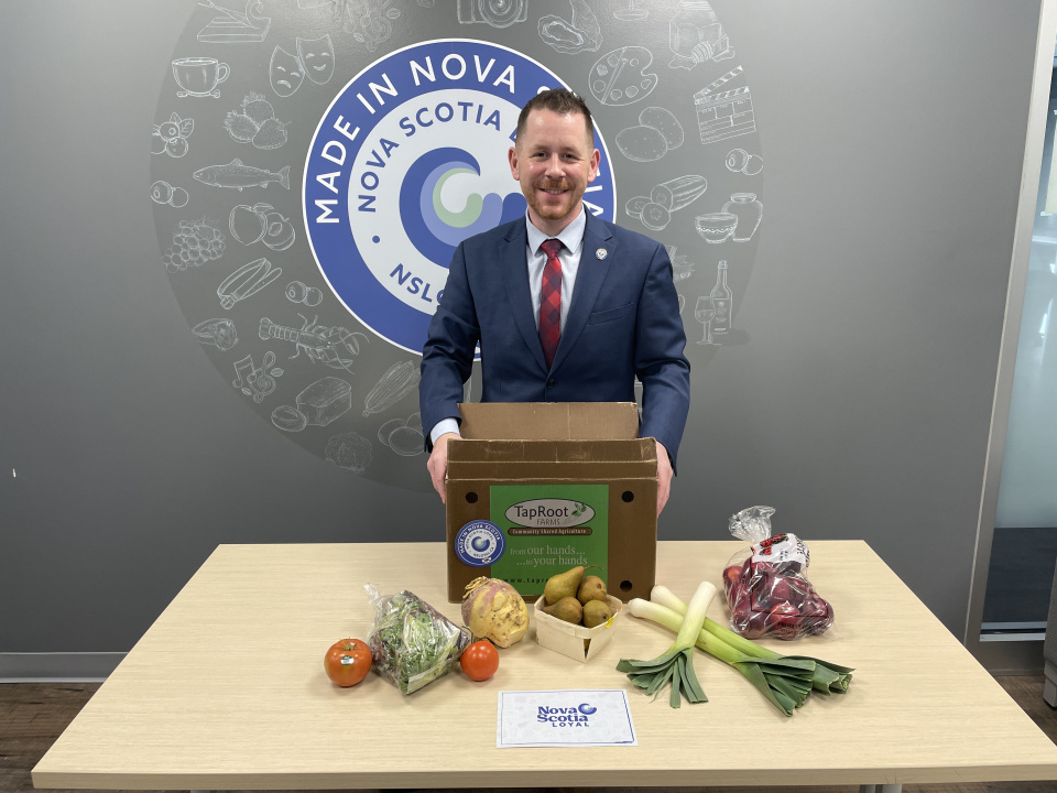 Colton LeBlanc, Minister of Growth and Development, with a food share box from TapRoot Farms in Port Williams.