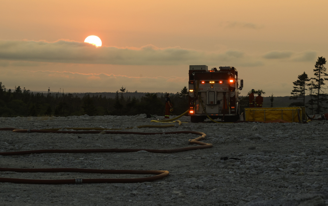 Fire hose on the ground behind a fire engine.