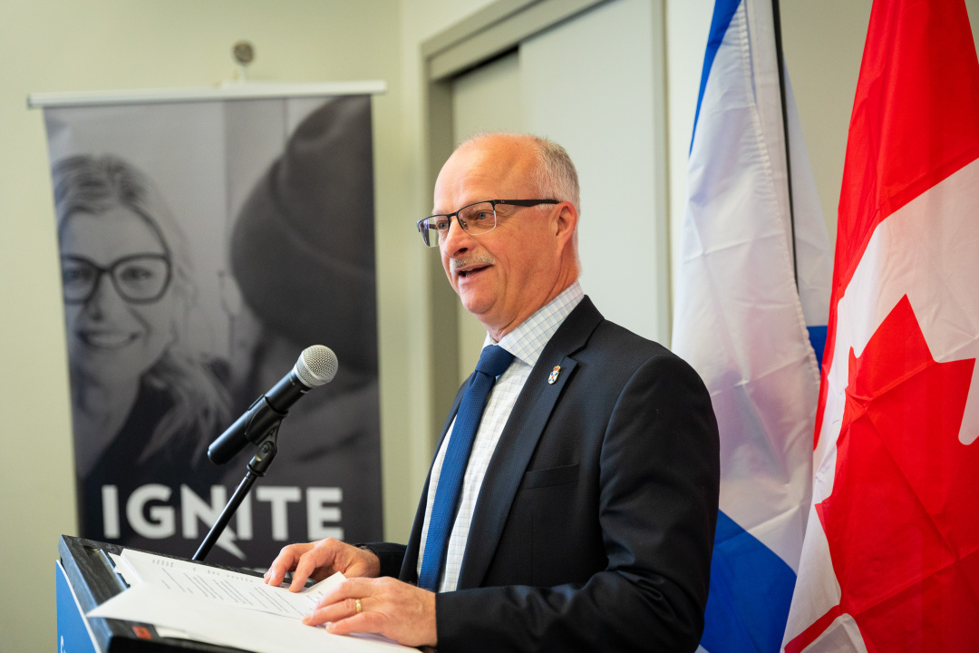 Housing Minister John White speaks at a podium