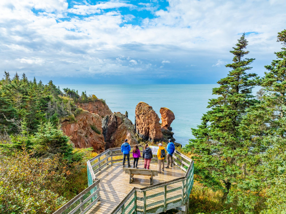 Visitors taking a guided tour of Cape Chignecto Provincial Park, looking out at the Three Sisters Sea Stacks.