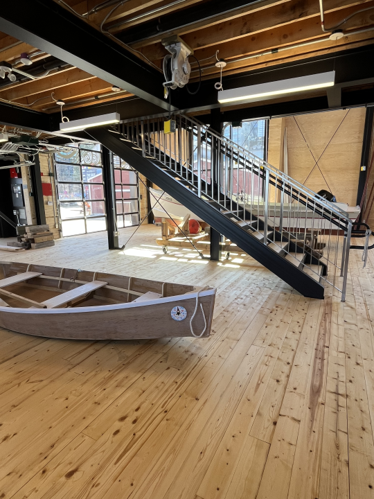 Boat School’s main floor alongside Bevin’s Skiff, a learning boat.
