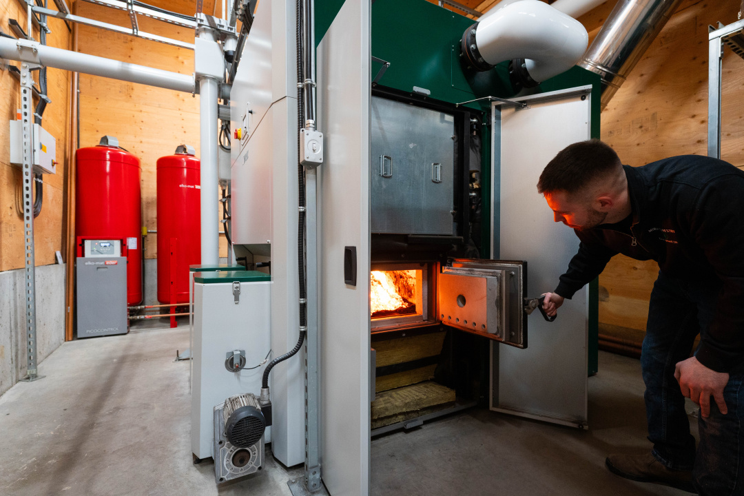 Landon Reginato, Manager of Operations with Mira Forestry in Cape Breton, inspects the wood-fueled furnace at Memorial High School in Sydney Mines. 