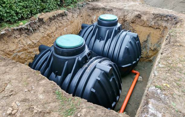 Two plastic water storage tanks in a hole in the ground
