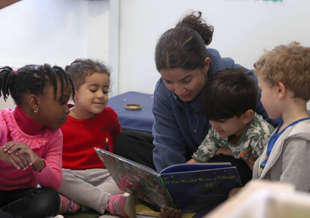 Children listening to an adult reading them a book