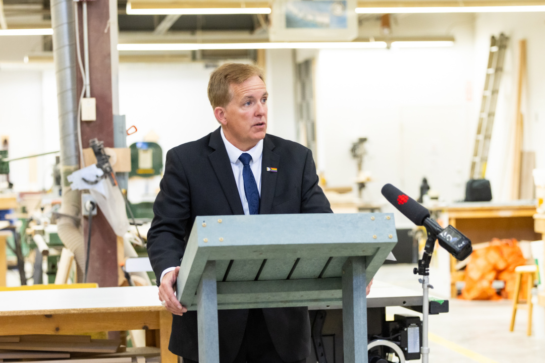 Justice Minister Scott Armstrong at a podium