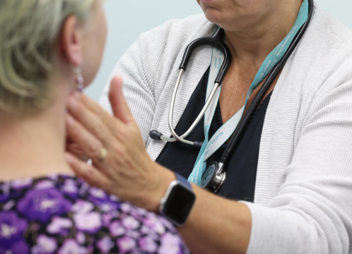 A healthcare professional examines a patient.