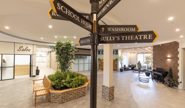 Several "street signs" pointing various directions in a common area in a new long-term care home