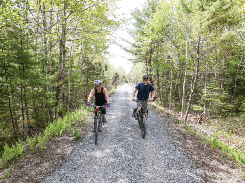 Two cyclists ride along a trail.