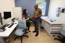 Two family doctors talking in a clinic exam room