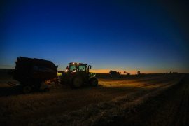 Farmers and equipment at work as the sun goes down.