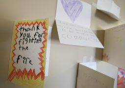 A handmade thank you card from a child to firefighters posted on a wall