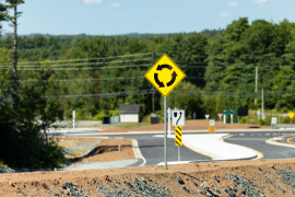 Roundabout road sign on a newly paved road.