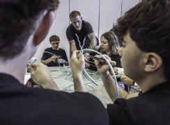A local fisher and business owner shows students how to splice rope.