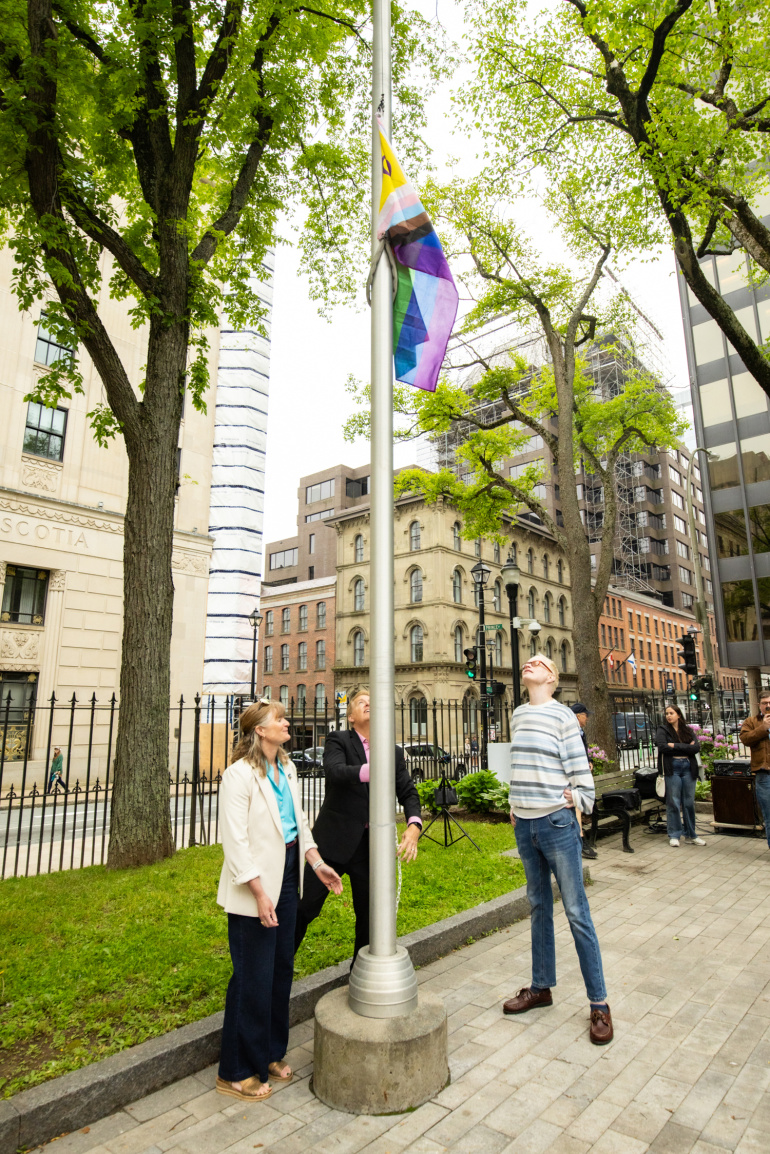 Deputy Minister Barbrick, Minister Armstrong and Steve Roy raised the Progress Pride flag 