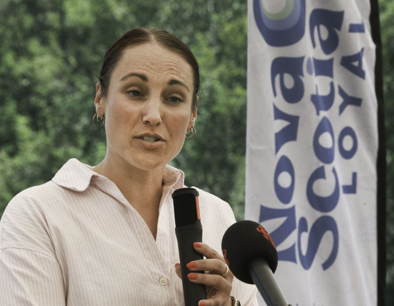 Geena Luckett holding a microphone at a podium