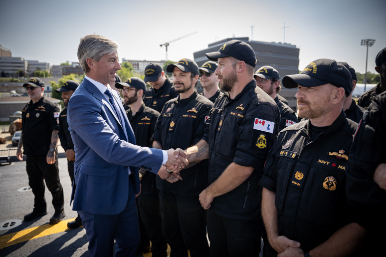 Premier Tim Houston shakes hands with members of the Canadian military.