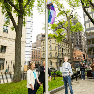 Deputy Minister Barbrick, Minister Armstrong and Steve Roy raised the Progress Pride flag 